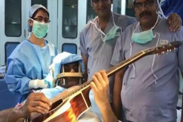 بالفيديو والصور - موسيقي هندي يعزف على الجيتار أثناء خضوعه لعملية جراحية